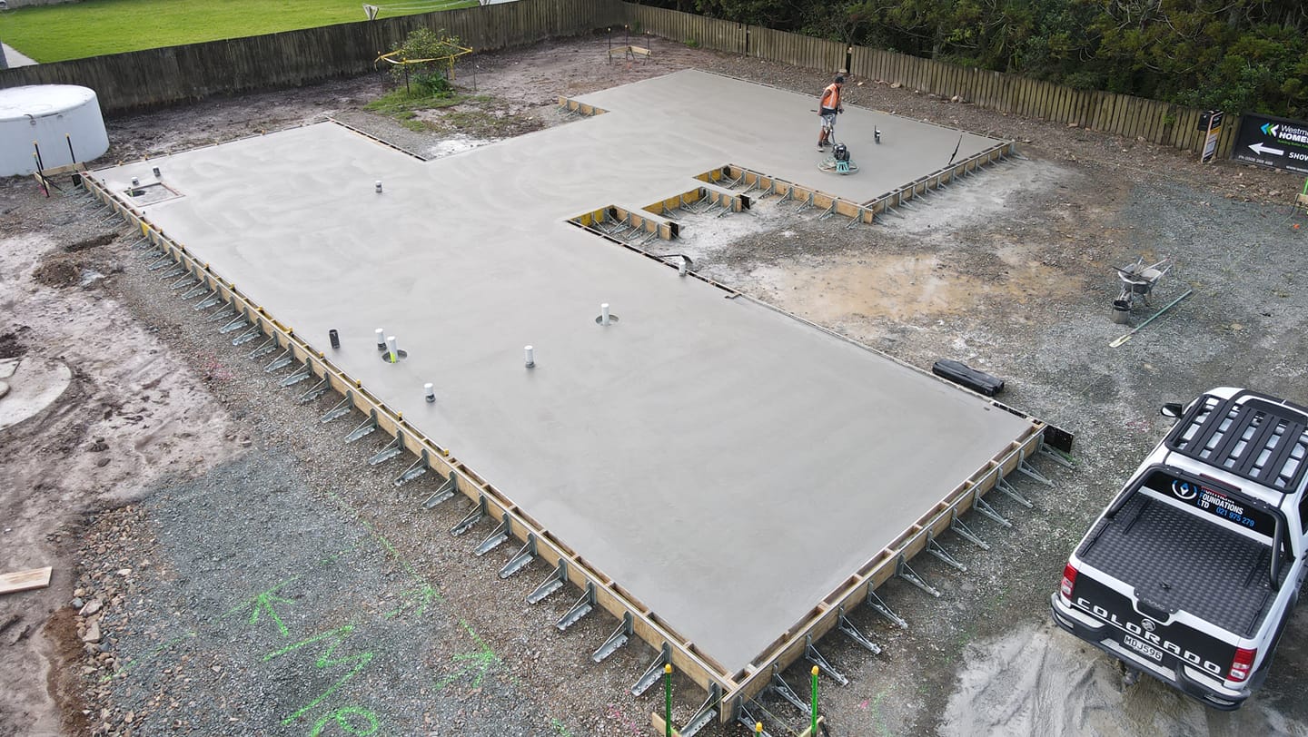 A freshly poured concrete slab seen from above, with a Northern Foundations ute beside it